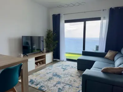 a living room with a blue couch and a television at Almar Ocean Retreat in Gaula