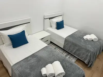 two beds in a room with blue and white at Refúgio Ponta do Sol - Madeira Inn Group in Ponta do Sol