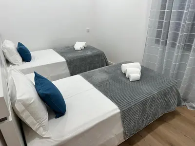 two beds in a room with blue pillows at Refúgio Ponta do Sol - Madeira Inn Group in Ponta do Sol