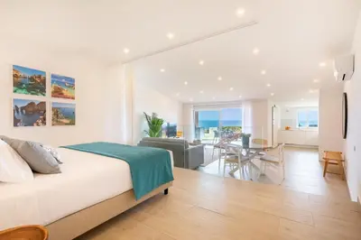 a bedroom with a large bed and a dining room at The Oceanfront Studio Luz VR110 in Luz