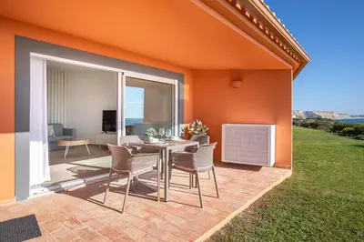 a patio with a table and chairs and a living room at The Oceanfront Studio Luz VR110 in Luz
