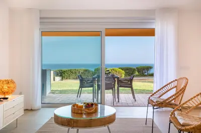 a living room with sliding glass doors and a table and chairs at The Oceanfront Studio Luz VR110 in Luz