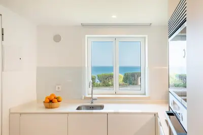 a white kitchen with a sink and a window at The Oceanfront Studio Luz VR110 in Luz