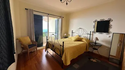 a bedroom with a bed and a view of the ocean at Casa Estrelada in Estreito da Calheta