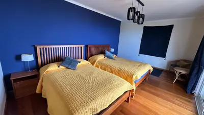 a bedroom with two beds with yellow and blue walls at Casa Estrelada in Estreito da Calheta
