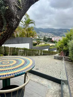 a table and a chair sitting on a patio at Modern Studio with Kitchen & Secure Parking in Funchal in Funchal