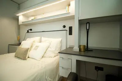 a bedroom with a bed with white sheets and pillows at Modern Studio with Kitchen & Secure Parking in Funchal in Funchal
