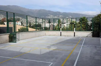 an empty tennis court with mountains in the background at Modern Studio with Kitchen & Secure Parking in Funchal in Funchal