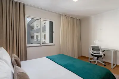 a bedroom with a bed and a desk and a chair at Madeira Ocean View by An Island Apart in Santa Cruz