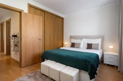 a bedroom with a large bed with a green blanket at Madeira Ocean View by An Island Apart in Santa Cruz