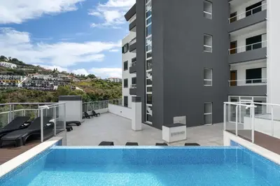 a swimming pool on the balcony of a building at Madeira Ocean View by An Island Apart in Santa Cruz
