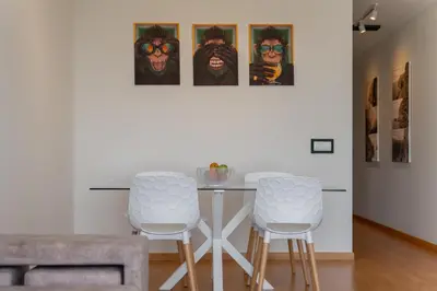 a dining room with a table and two stools at Madeira Ocean View by An Island Apart in Santa Cruz