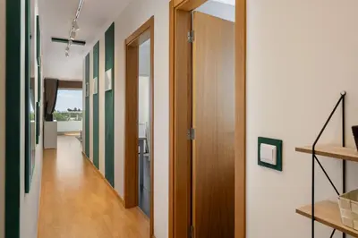 a hallway with wooden doors and green and white walls at Madeira Ocean View by An Island Apart in Santa Cruz