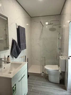a bathroom with a shower and a toilet and a sink at Pousada Teixeira 11A in São Vicente