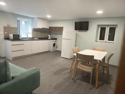 a kitchen and a table and chairs in a room at Pousada Teixeira 11B in São Vicente