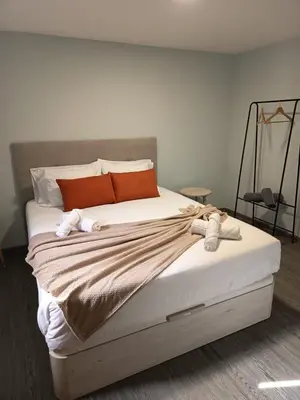 a bedroom with a large bed with orange pillows at Pousada Teixeira 11B in São Vicente