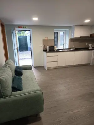 a living room with a couch and a kitchen at Pousada Teixeira 11B in São Vicente