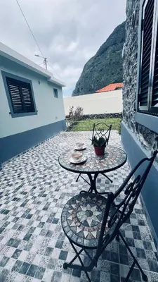 a courtyard with a building and a mountain at Pousada Teixeira 11B in São Vicente