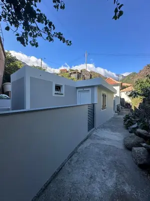 a house with a white wall and a driveway at Old Aqueduct Village 2 - Guesthouse Madeira in Serra de Água