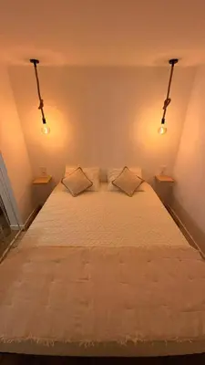 a bedroom with a bed with a light on the wall at Old Aqueduct Village 2 - Guesthouse Madeira in Serra de Água