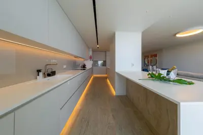 a kitchen with white countertops and a long line of counters at Savoy Monumentalis Ocean View By LM & AC Signature in Funchal