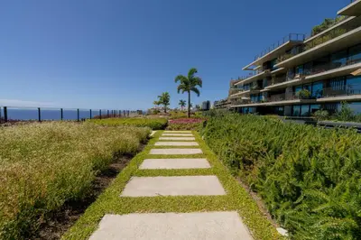 a pathway leading to the beach with a building at Savoy Monumentalis Ocean View By LM & AC Signature in Funchal