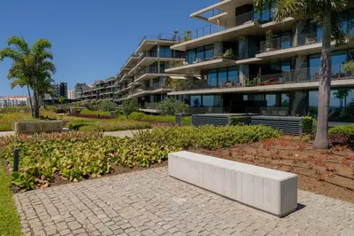 a bench in a garden in front of a building at Savoy Monumentalis Ocean View By LM & AC Signature in Funchal