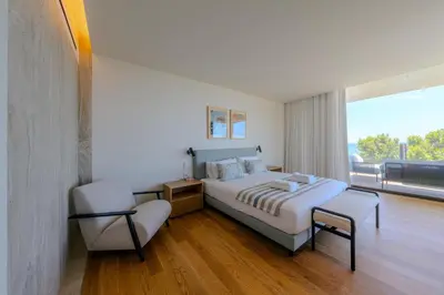 a bedroom with a bed and a chair and a window at Savoy Monumentalis Ocean View By LM & AC Signature in Funchal