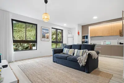 a living room with a blue couch and a kitchen at MK Apart II in Funchal
