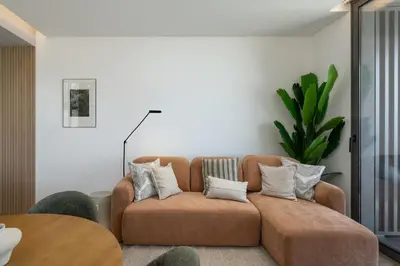 a living room with a brown couch with pillows at Calheta Hills III by An Island Apart in Calheta