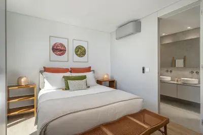 a white bedroom with a large bed and a bathroom at Calheta Hills III by An Island Apart in Calheta