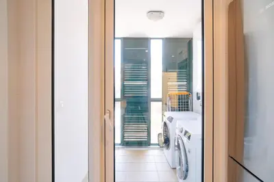 a bathroom with a washing machine and a window at Giraffa by Wanderlust Madeira - 3 Bedroom apartment in Funchal