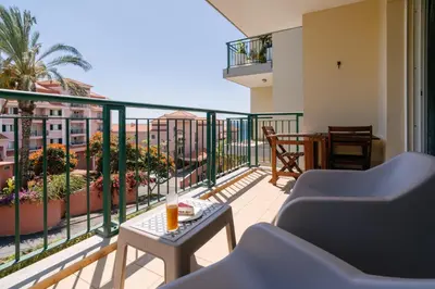 a balcony with a table and chairs on a balcony at Giraffa by Wanderlust Madeira - 3 Bedroom apartment in Funchal