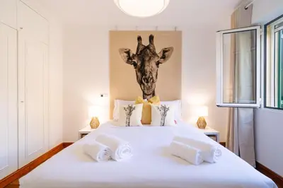 a bedroom with a bed with a giraffe head on the wall at Giraffa by Wanderlust Madeira - 3 Bedroom apartment in Funchal