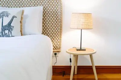a bedroom with a bed with a lamp on a table at Giraffa by Wanderlust Madeira - 3 Bedroom apartment in Funchal
