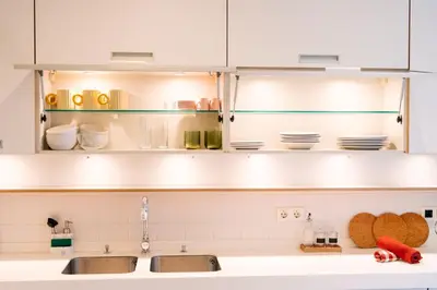 a kitchen with white cabinets and a sink at Giraffa by Wanderlust Madeira - 3 Bedroom apartment in Funchal