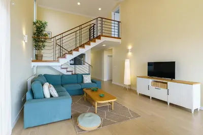 a living room with a blue couch and a staircase at Villa Pargo Green by Madeira Dream Stays in Ponta do Pargo