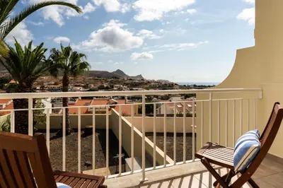 a balcony with two chairs and a view of the ocean at Gonçalves Guest House by An Island Apart in Porto Santo