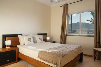 a bedroom with a bed and a large window at Gonçalves Guest House by An Island Apart in Porto Santo