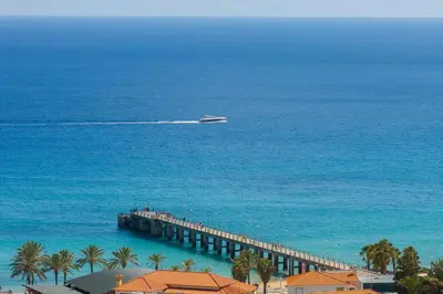 a boat in the ocean next to a pier at Gonçalves Guest House by An Island Apart in Porto Santo
