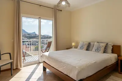 a bedroom with a bed and a large window at Gonçalves Guest House by An Island Apart in Porto Santo