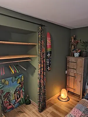a bedroom with a surfboard hanging on the wall at This Old House in Ponta do Pargo