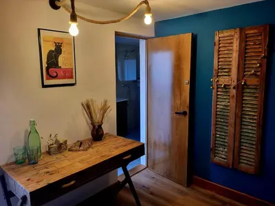 a room with a wooden table and a blue wall at This Old House in Ponta do Pargo