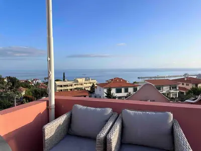 a couch on a balcony with a view of the ocean at VILLA Valhalla Private heated swimming-pool in Funchal