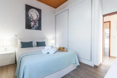a white bedroom with a bed with towels on it at Villa Magnolia by Atlantic Holiday in Machico
