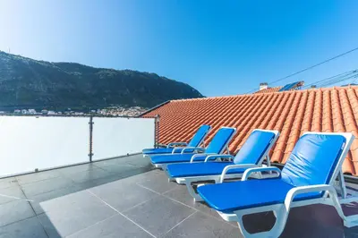 a row of blue chairs sitting on a roof at Villa Magnolia by Atlantic Holiday in Machico