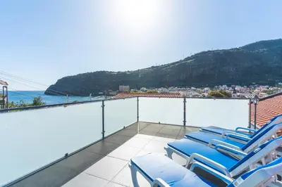 a group of blue lounge chairs on a balcony at Villa Magnolia by Atlantic Holiday in Machico