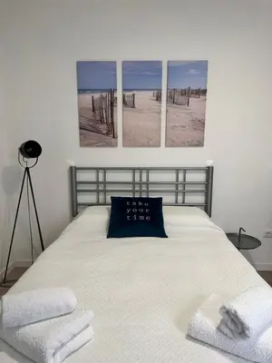 a bedroom with a bed with four pictures on the wall at Valhalla Madeira Apartements in Funchal
