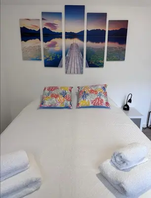 a bedroom with a bed with four paintings on the wall at Valhalla Madeira Apartements in Funchal