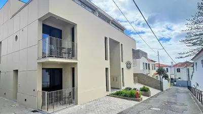 a white building with balconies on a street at Valhalla Madeira Apartements in Funchal